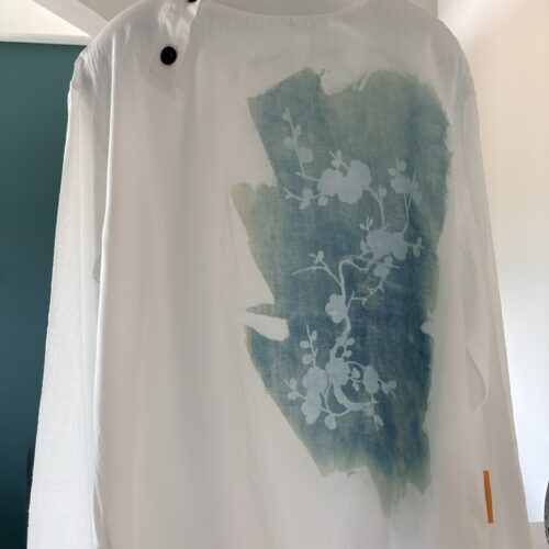 Woman, white blouse, cherry blossom branch on a pastel blue background